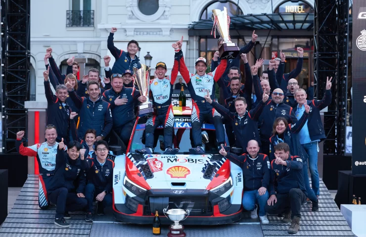 The Hyundai WRT team celebrates with Thierry Neuville and their 2024 WRC-winning Hyundai i20 N on the Monte-Carlo podium.