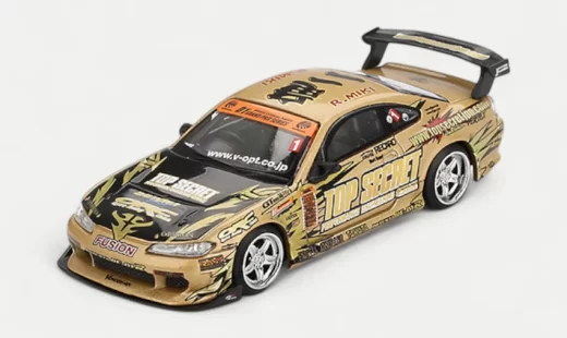 A front three-quarters view of the MINI GT 1/64 Top Secret Nissan Silvia S15 D1GP Gold, showcasing its complex and iconic sponsor livery.