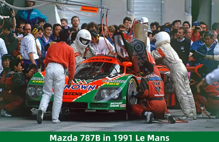The legendary #55 Mazda 787B in the pits during its historic overall victory at the 1991 24 Hours of Le Mans, surrounded by the Mazdaspeed team.