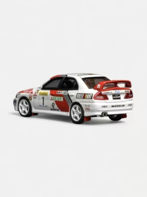 The rear three-quarter view of the Mitsubishi Evo IV model in 1:64 scale, highlighting the iconic high wing, mud flaps, and Monte Carlo livery.