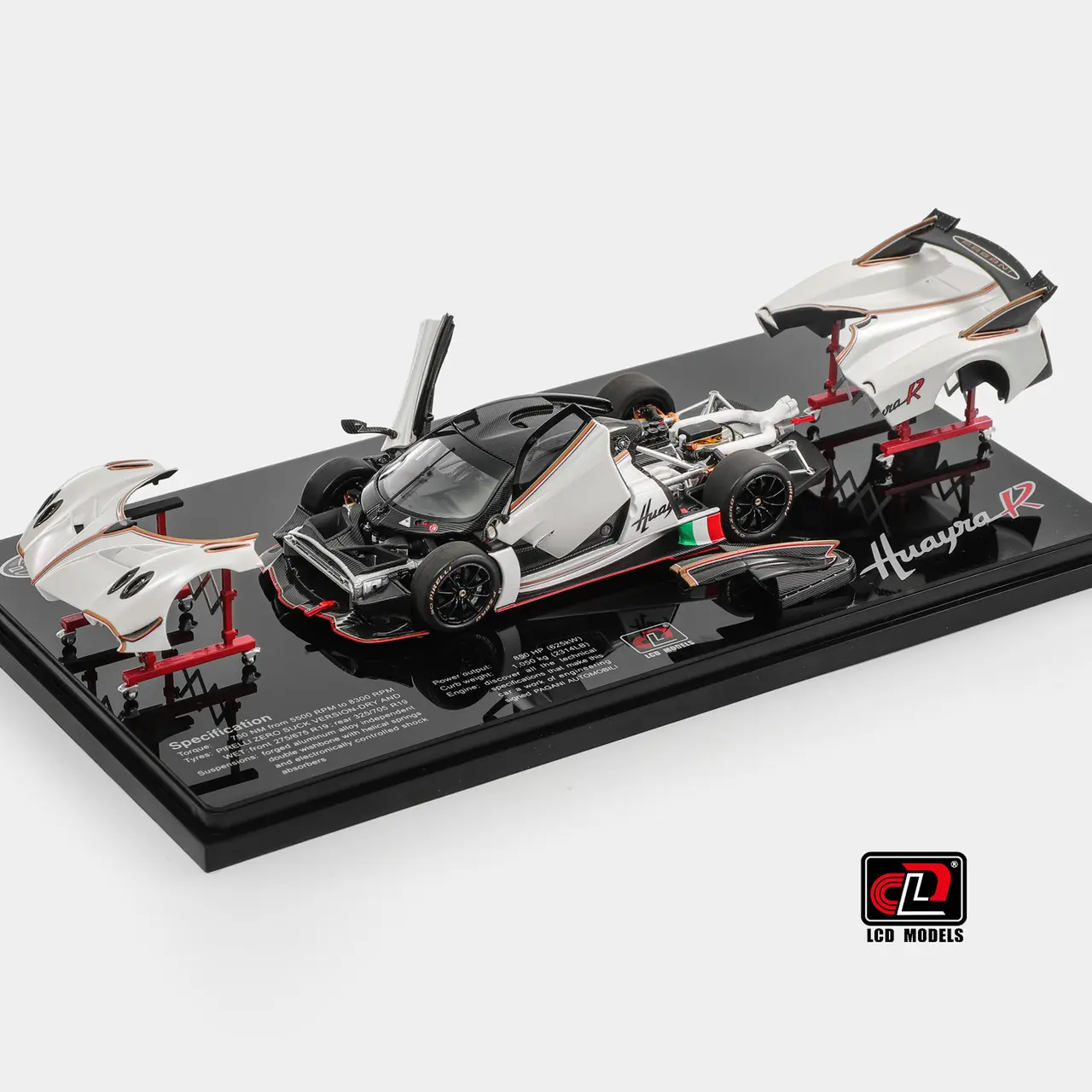 An "exploded" view of the model with removable body panels, the 1:43 Pagani Huayra R, showing the chassis and all of its separate white body parts on stands.