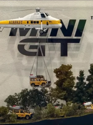 Scale model display for MINI GT AC38 set. An Airfast (PK-OAF) helicopter lifts a Camel Trophy Land Rover.